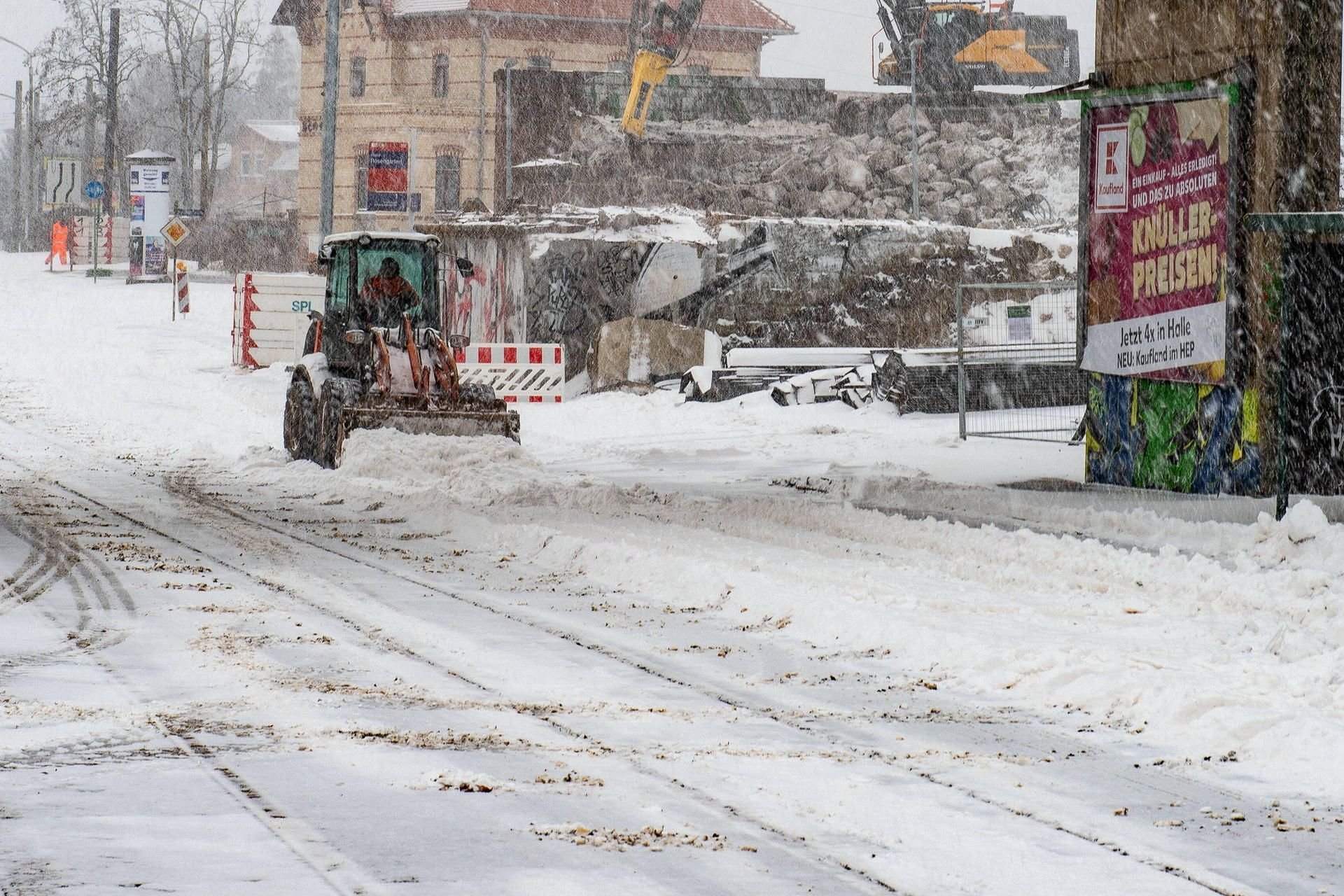 Wintereinbruch mit großen Schneemengen auch in Halle: Ein Fahrzeug räumt an einer Baustelle im Wohngebiet Rosengarten / Merseburger Straße.