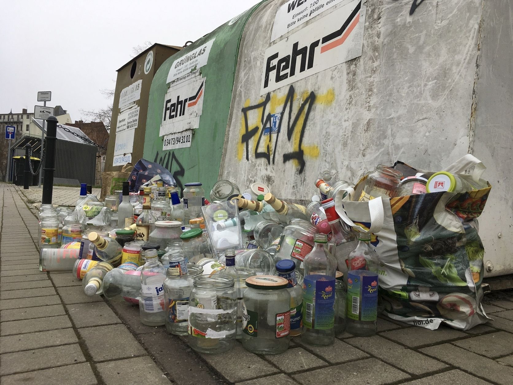 An der Badergasse in Bernburg liegt haufenweise Altglas vor den vollen Iglus.
