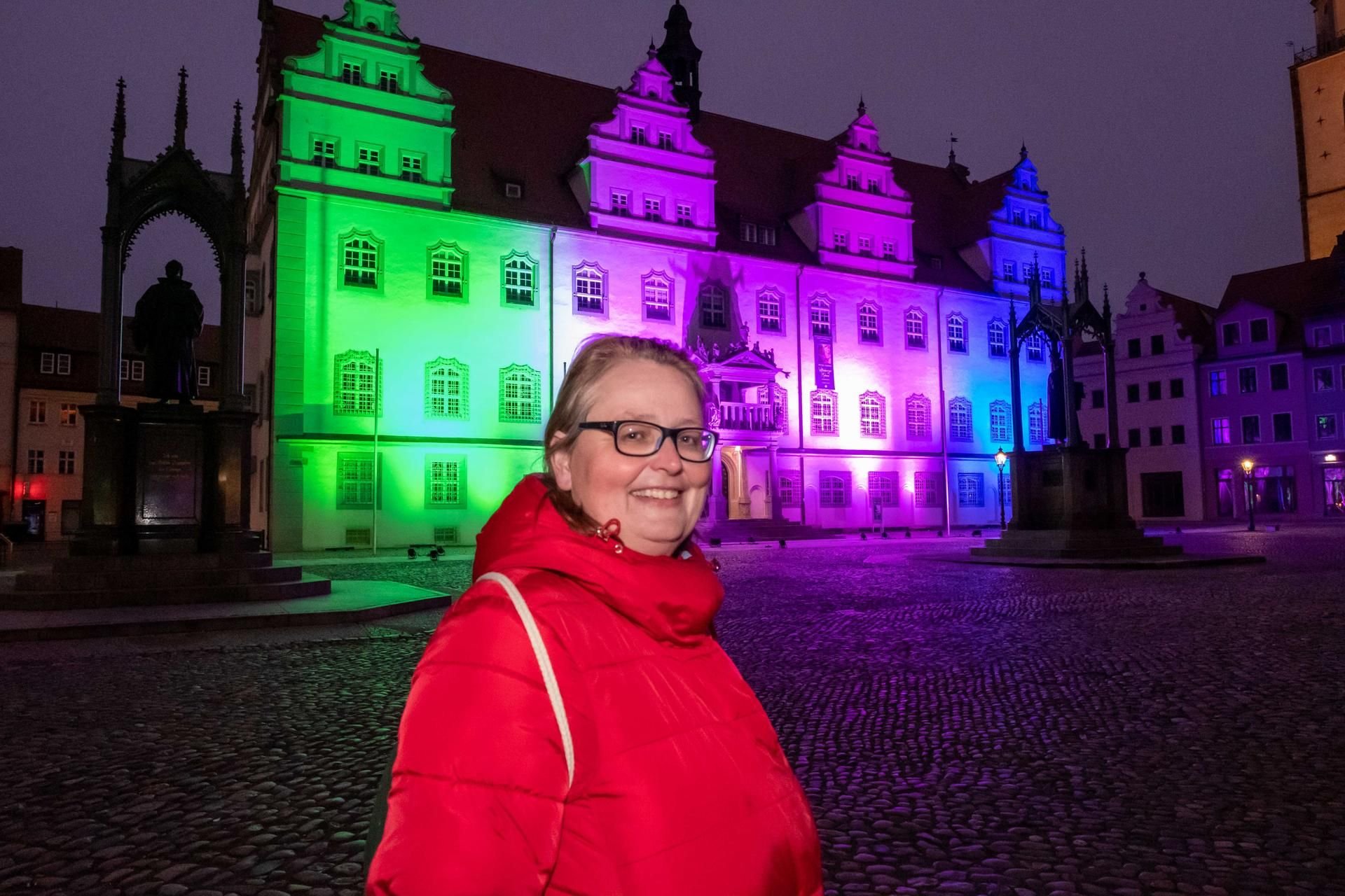 Annette Byhahn vor dem Rathaus in Wittenberg, das anlässlich des 11. Tages der seltenen Erkrankungen Sonntagabend beleuchtet wurde.