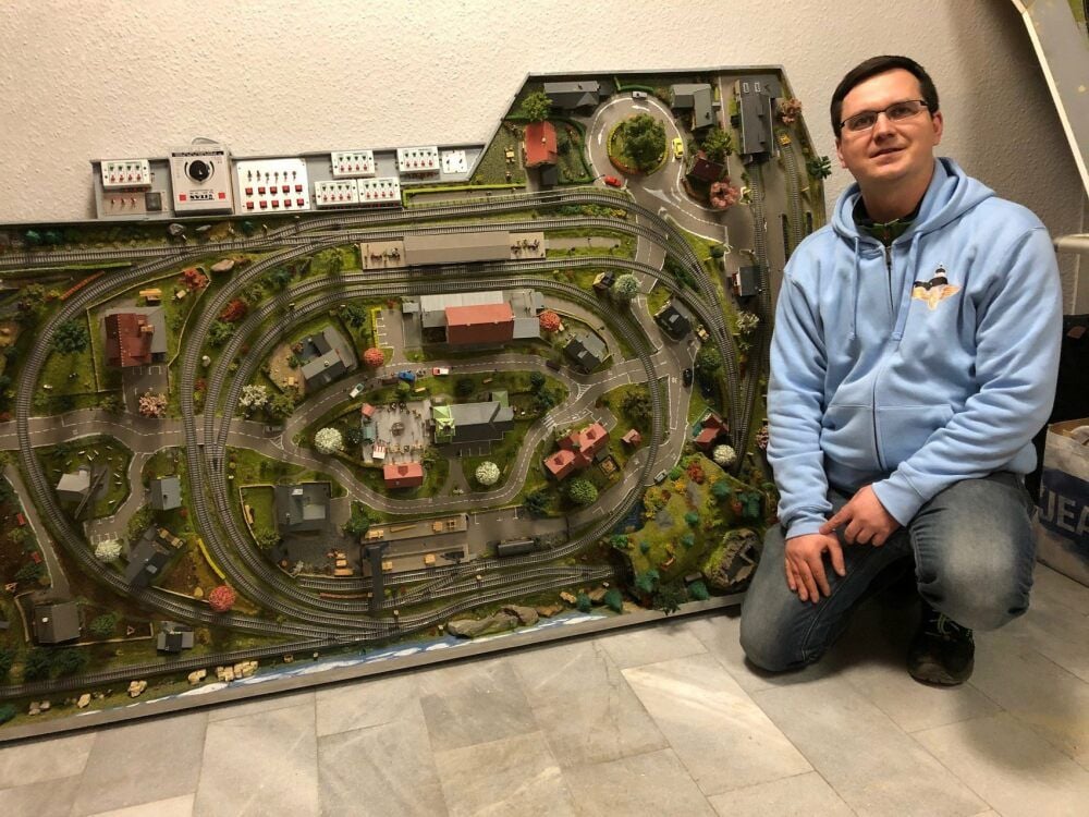 Der Vereinsvorsitzende Hagen Kalweit zeigt eine der Modellbahnanlagen, die jetzt im Bastelraum zu finden sind.