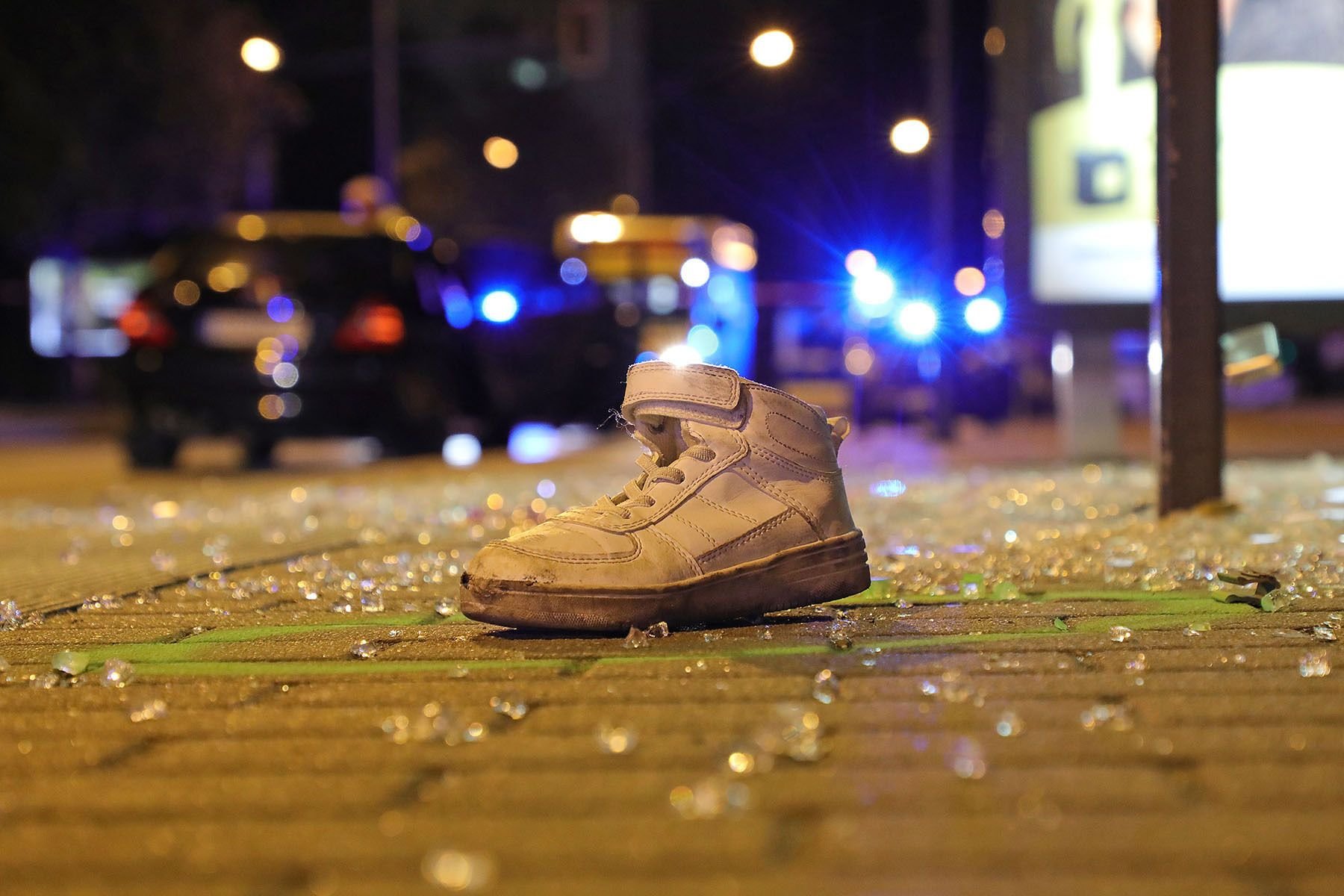 Ein Sportschuh liegt nach einem Verkehrsunfall an einer Bushaltestelle in einem Farbkreis der Spurensicherung der Polizei. Bei dem Unfall war ein Junge tödlich verletzt worden.