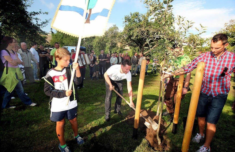 Freyburgs Bürgermeister Udo Mänicke pflanzt einen Apfelbaum und verspricht einen Kinderspielplatz.
