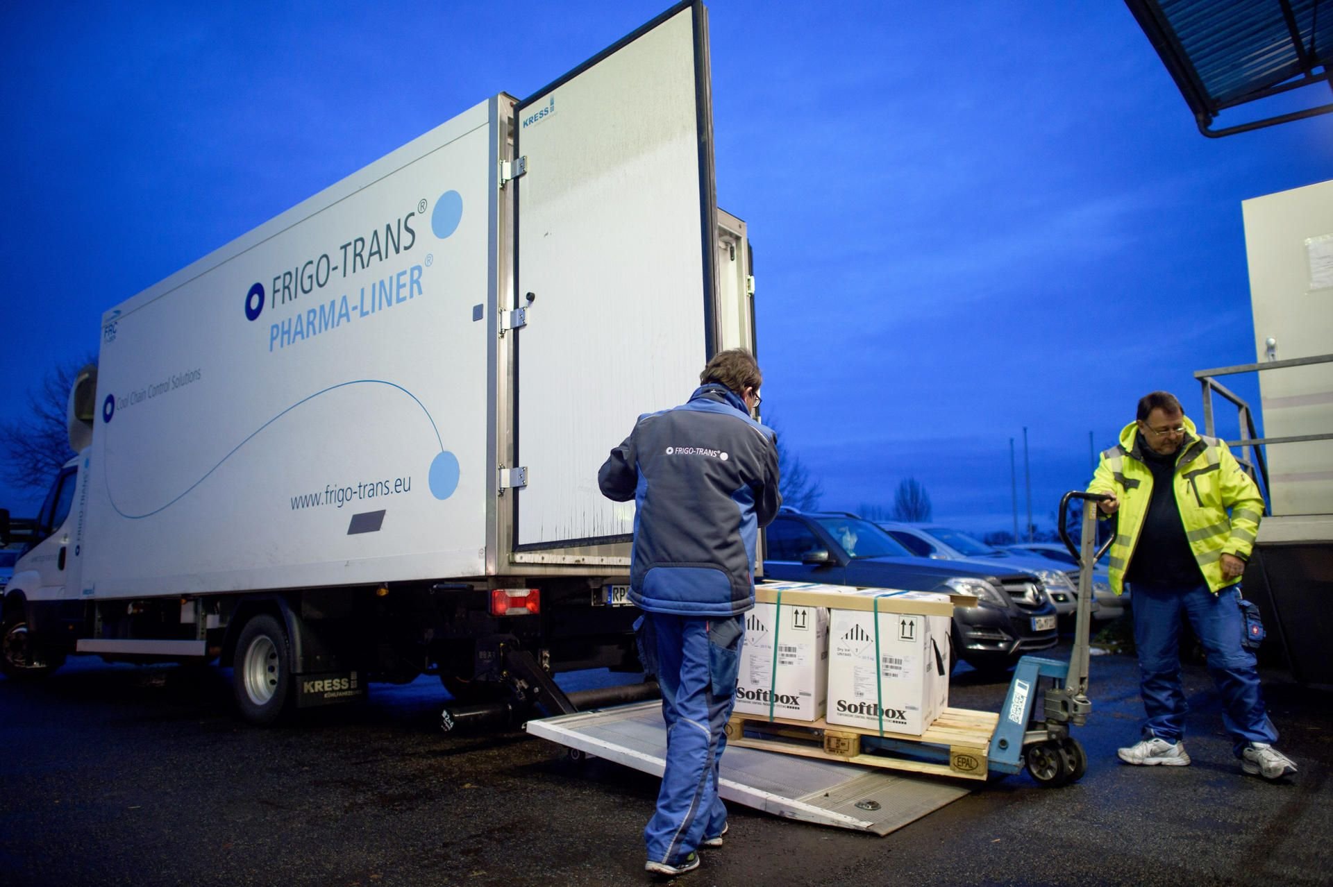 Fahrer eines Kühllastwagens entladen in einem Logistikzentrum in Irxleben (Sachsen-Anhalt) Kisten mit Impfdosen von Biontech/Pfizer.