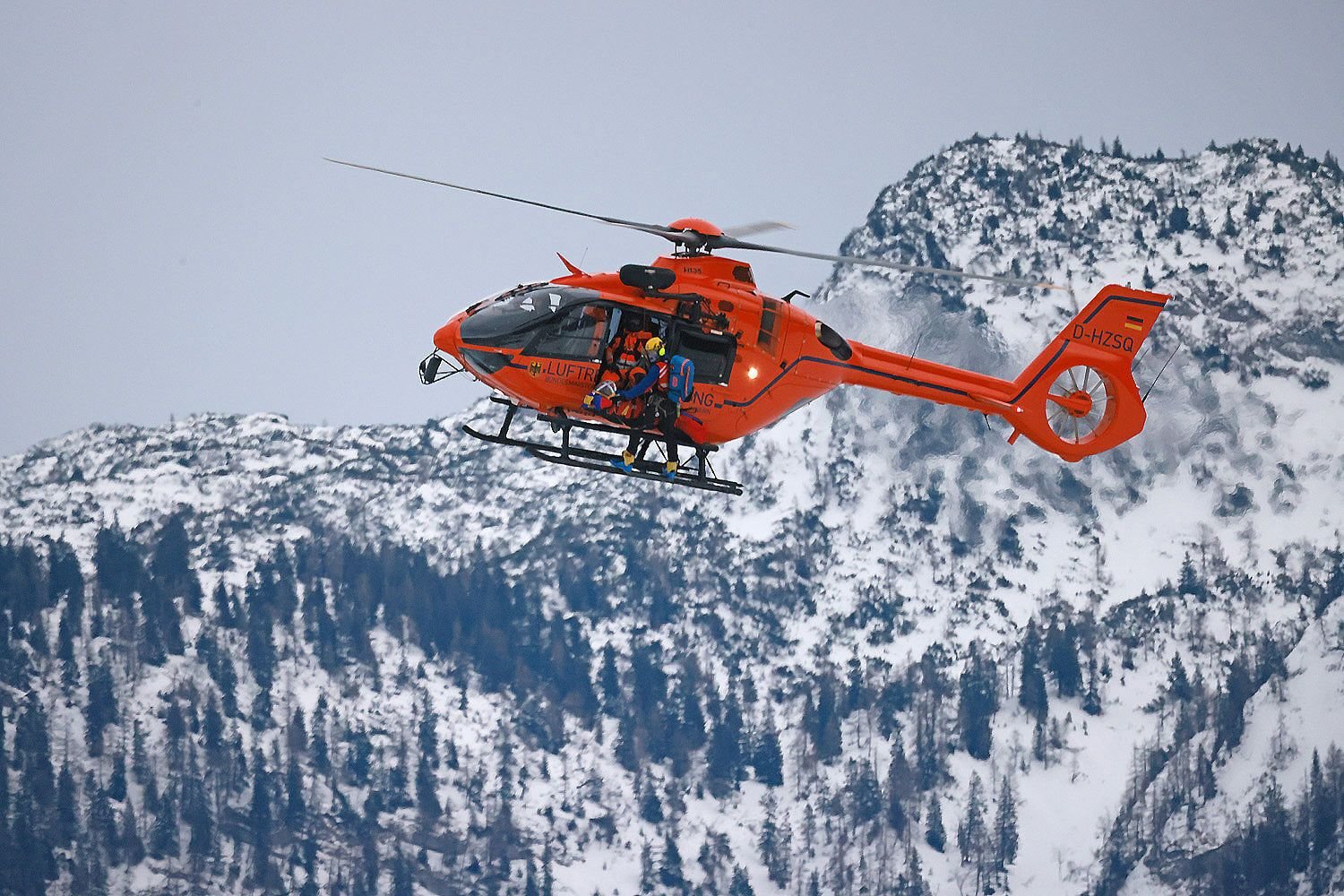 Ein Rettungshubschrauber fliegt über ein Skigebiet. (Symbolbild)
