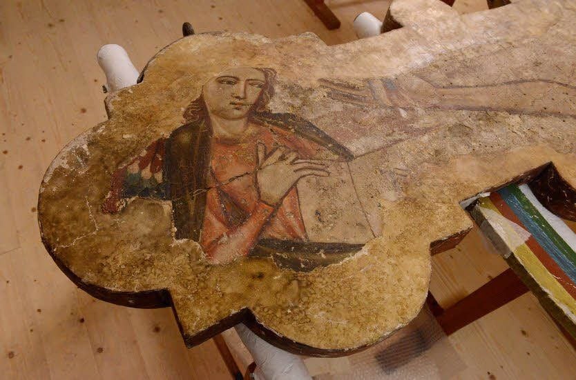 Das Holzkreuz zeigt unter anderem das Symbol des Evangelisten Matthäus.