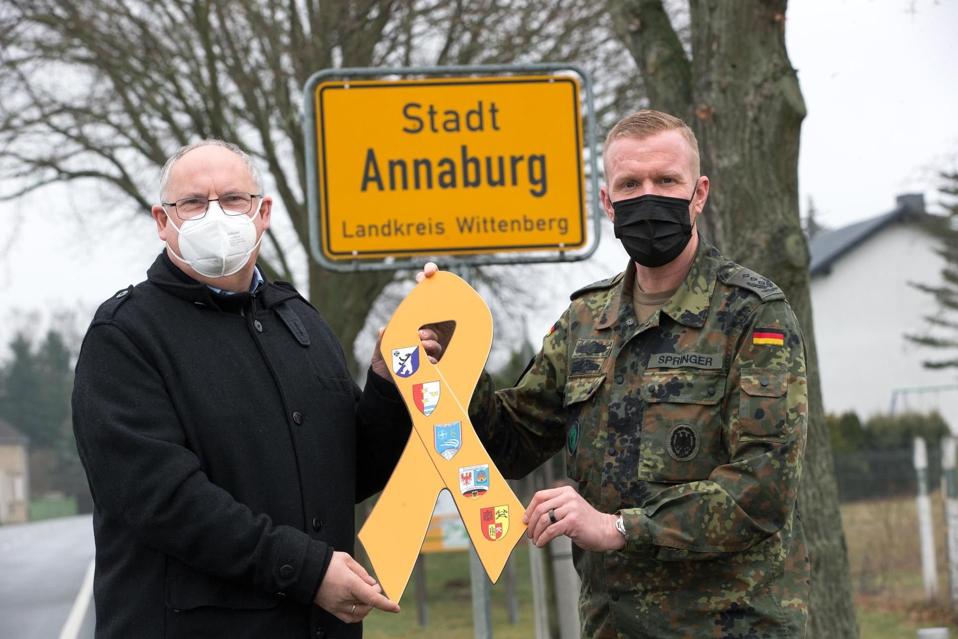 Mit der Übergabe der Gelben Schleife am Ortseingang von Annaburg setzen Oberst Andreas Springer und Bürgermeister Klaus-Rüdiger Neubauer ein Zeichen für die Verbundenheit mit der Bundeswehr.