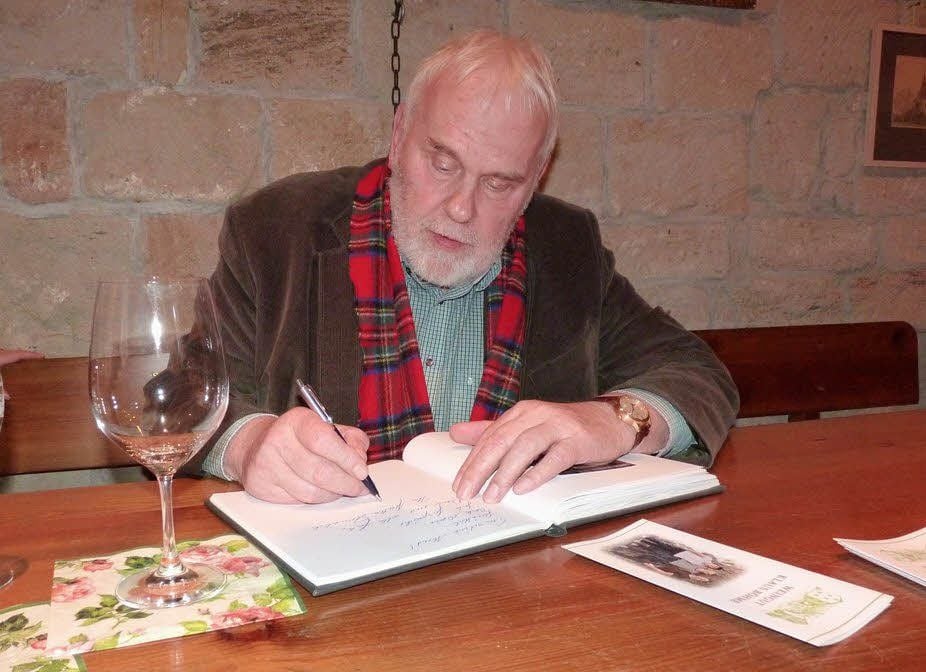 Weinbotschafter Emmerlich schreibt sich im Weingut Klaus Böhme in das Gästebuch ein.