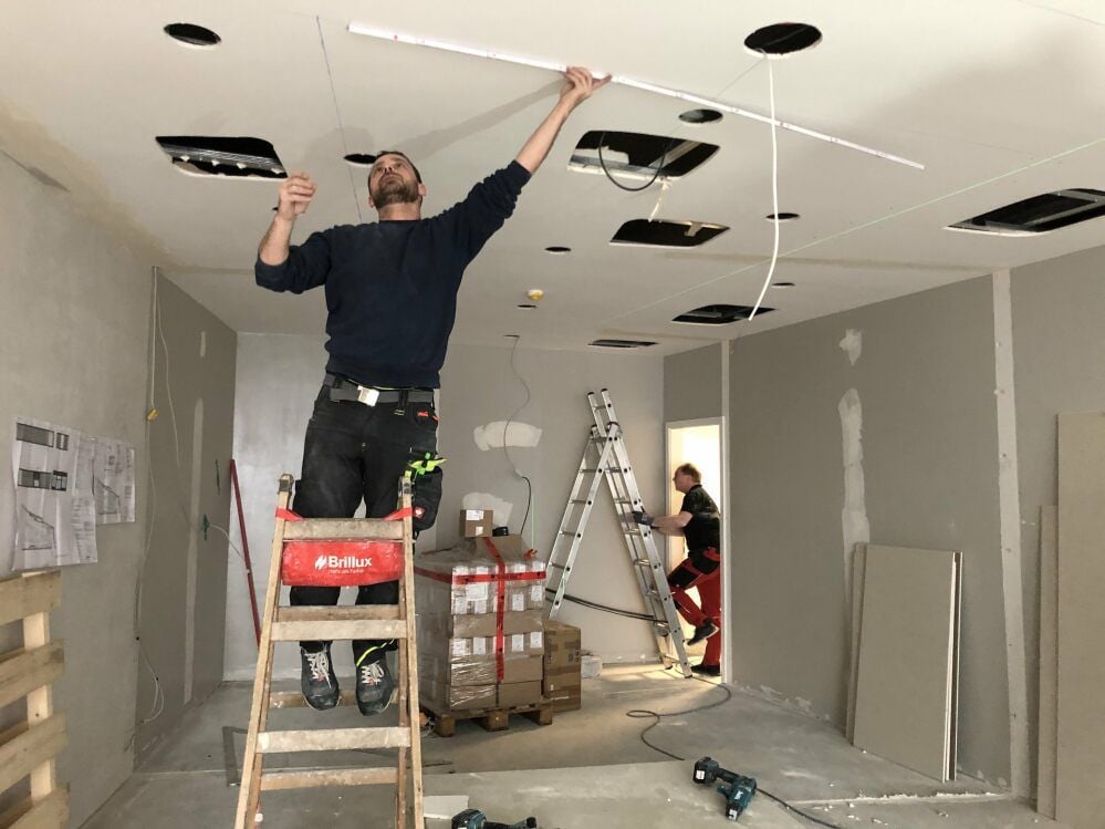 Umbau im neuen Geschäft: Fabian Lassak beim Abmessen an der Decke für den Einbau der neuen Lichtschienen.