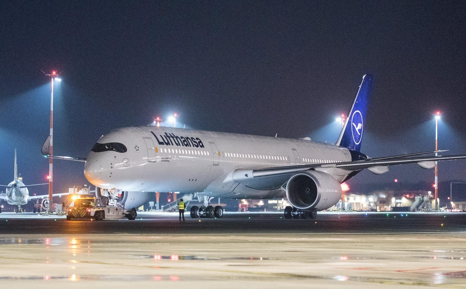 Ein Lufthansa-Flugzeug vom Typ Airbus A350-900 fährt am Abend auf dem Hamburger Flughafen in Richtung der Startbahn.