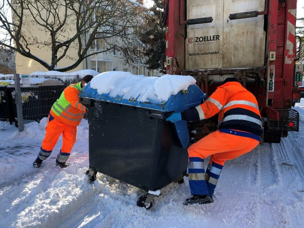Den Müllbehälter zum Fahrzeug zu bringen, ist Schwerstarbeit für Manfred Beier (links) und René Reichel.
