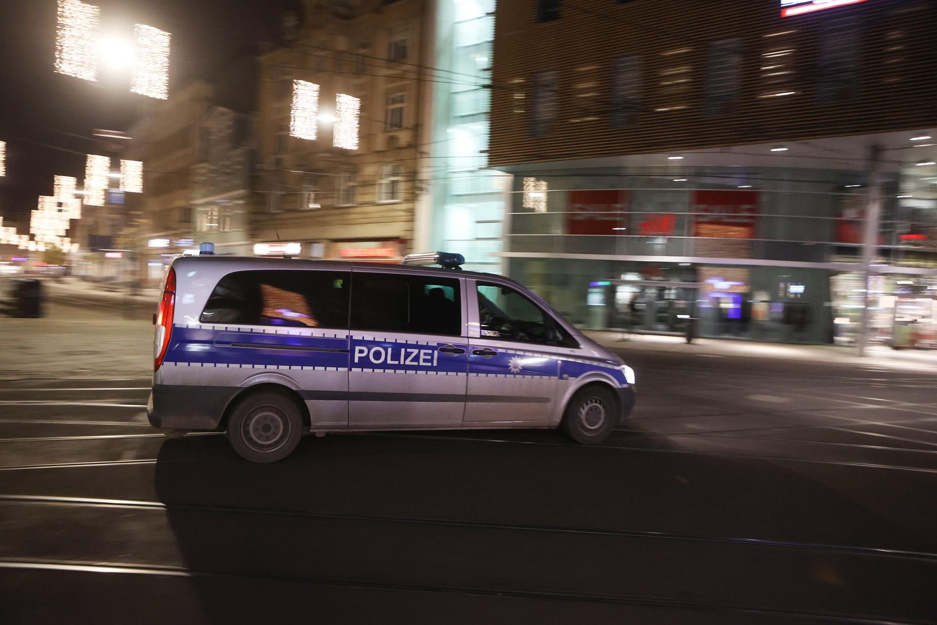 Ein Polizeifahrzeug fährt durch eine fast menschenleere Innestadt.