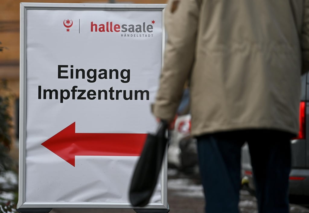 Ein Schild vor dem Impfzentrum in Halle/Saale weist den Weg zum Eingang.