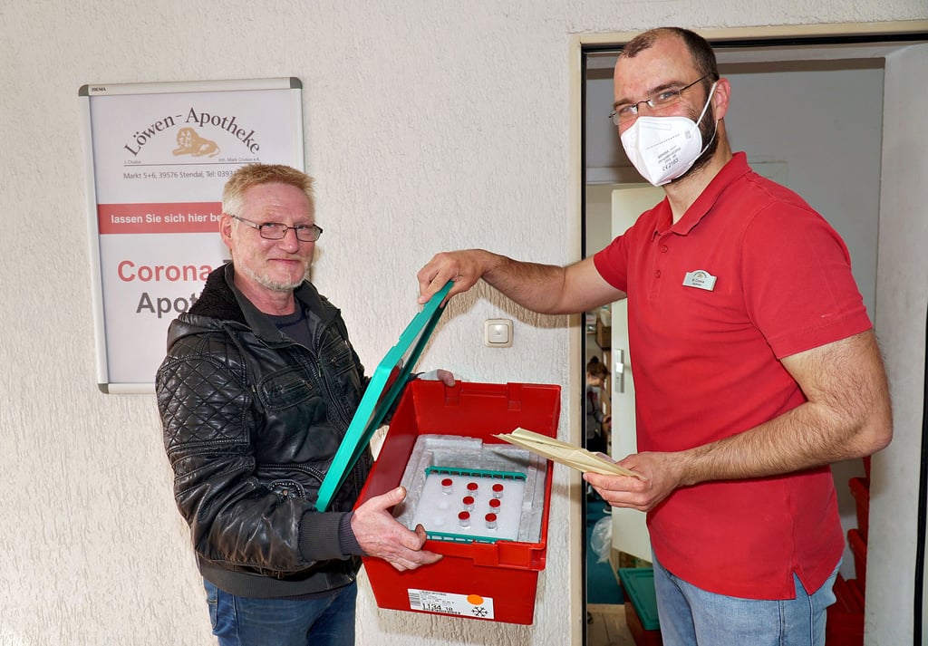 Mark Crusius (rechts), Inhaber der Löwen-Apotheke in Stendal bekommt eine Lieferung von Impfstoffen der Firmen Biontech/Pfizer und Astrazeneca. Kurierfahrer Ralf Reichmann übergibt die Medikamente in Kühlboxen.