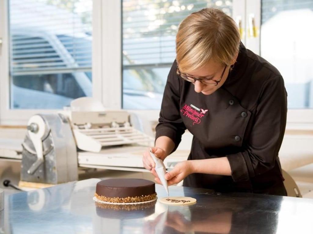 Konditoren machen Kuchen und Torten zu echten Unikaten: Hier verziert Sophie Meier ein Exemplar mit Schokoschrift. Foto: Tobias Hase