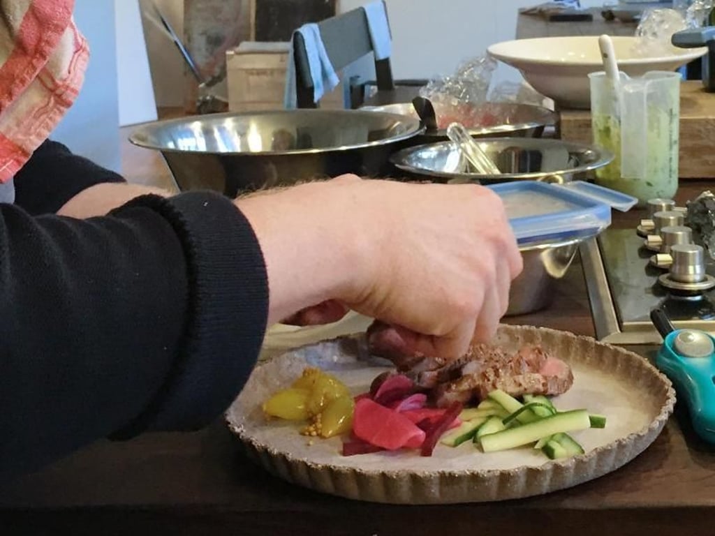 Volle Konzentration beim Anrichten: Food-Stylist Max Faber ordnet noch einmal Steak, Kartoffelchips und Gemüse auf dem Teller ansprechend an, bevor das Gericht fotografiert wird. Foto: Tom Nebe/dpa/dpa-tmn