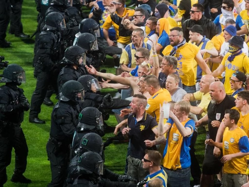 Barriere zwischen verfeindeten Fußballfans: Polizisten verhindern im Mai 2017 nach dem Bundesliga-Relegationsspiel zwischen Braunschweig und Wolfsburg gewalttätige Auseinandersetzungen. Foto: Julian Stratenschulte