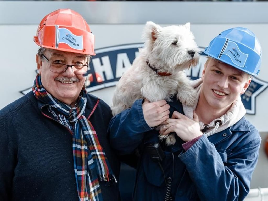 Julian Schnieders (r), Auszubildender zum Binnenschiffer, mit seinem Kapitän und Ausbilder Johann Bergmann und Bordhund Tobbi an Bord des Tankschiffes «Charisma». Foto: Markus Scholz