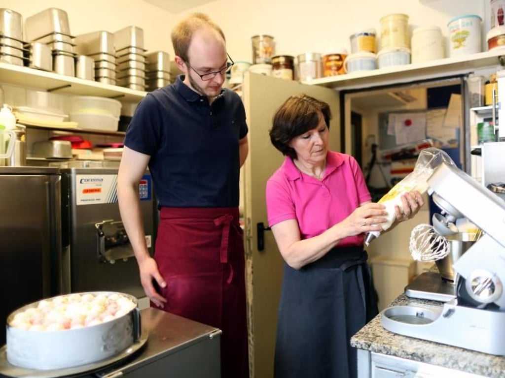 Eisdielen sind häufig kleine, familiengeführte Betriebe. So ist es auch bei Azubi Manuel Rütter. Er lernt bei seinen Eltern. Hier schaut er seiner Mutter bei der Sahneherstellung über die Schulter. Foto: Ina Fassbender
