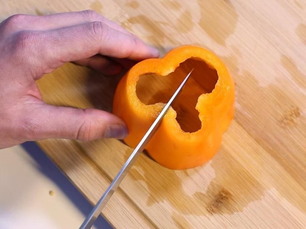 Schritt 4: Die Paprika aufstellen und einmal von oben nach unten durchschneiden. Foto: Karolin Krämer
