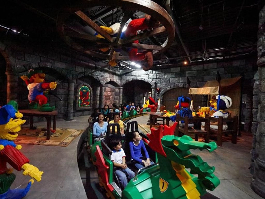 Die Achterbahn The Dragon im Legoland Dubai fährt auch durch ein dunkles Gemäuer voll mit riesigen Legofiguren. Foto: Dubai Parks and Resorts