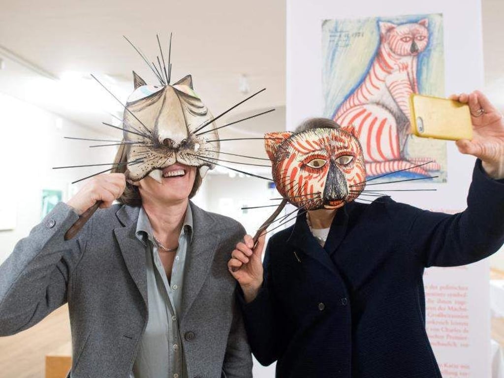 Pressesprecherin Annette Langhorst (l) und Direktorin Gisela Vetter-Liebenow mit «Selfie-Masken» in der Ausstellung «Zahme Viecher & wilde Bestien» im Museum Wilhelm Busch. Foto: Julian Stratenschulte
