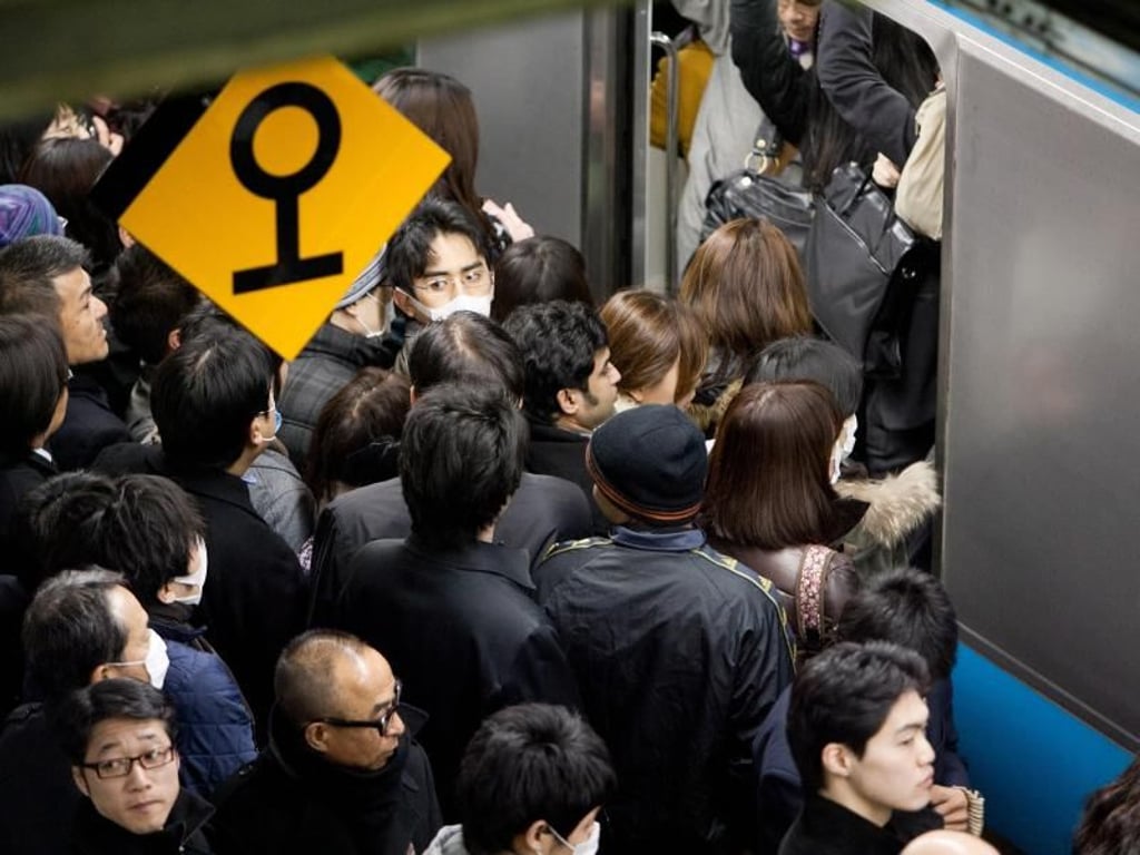 Pendler drängeln sich in Tokio in eine U-Bahn. Foto: Christopher Jue