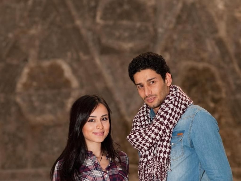 Die aus Damaskus stammende Syrerin Rita Albahr und der aus Bagdad stammende Iraker Hussam Zahim Mohammed im Museum für Islamische Kunst vor der Mauer des ehemaligeb Kalifenschlosses Mschatta. Foto: Klaus-Dietmar Gabbert