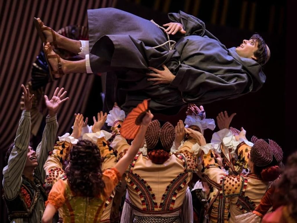 Sancho Pansa (Nicolas Gläsmann) wird vom Ensemble in die Höhe geworfen. Foto: Axel Heimken