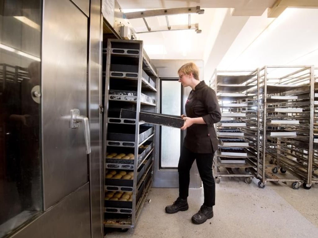 Hier zieht die Auszubildende Sophie Meier in der Backstube ihres Ausbildungsbetriebs in München ein Blech Dampfnudeln aus dem Gärschrank. Foto: Tobias Hase