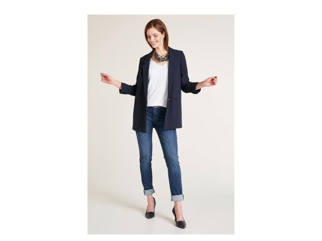 Ein weit geschnittener dunkelblauer Blazer passt zu fast allem. Auch Heine hat die weit und extralang bis über den Po geschnittenen Modelle, die derzeit im Trend liegen, im Programm (Blazer ca. 80 Euro, Jeans ca. 60 Euro, Top ca. 30 Euro, Pumps ca. 120 Euro). Foto: Heine