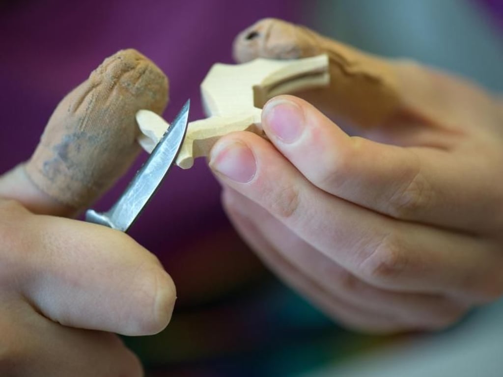 In der Ausbildung zum Holzspielzeugmacher lernen Jugendliche, zu schnitzen. Sie beschäftigen sich aber auch mit modernen CNC-Maschinen. Foto: Arno Burgi