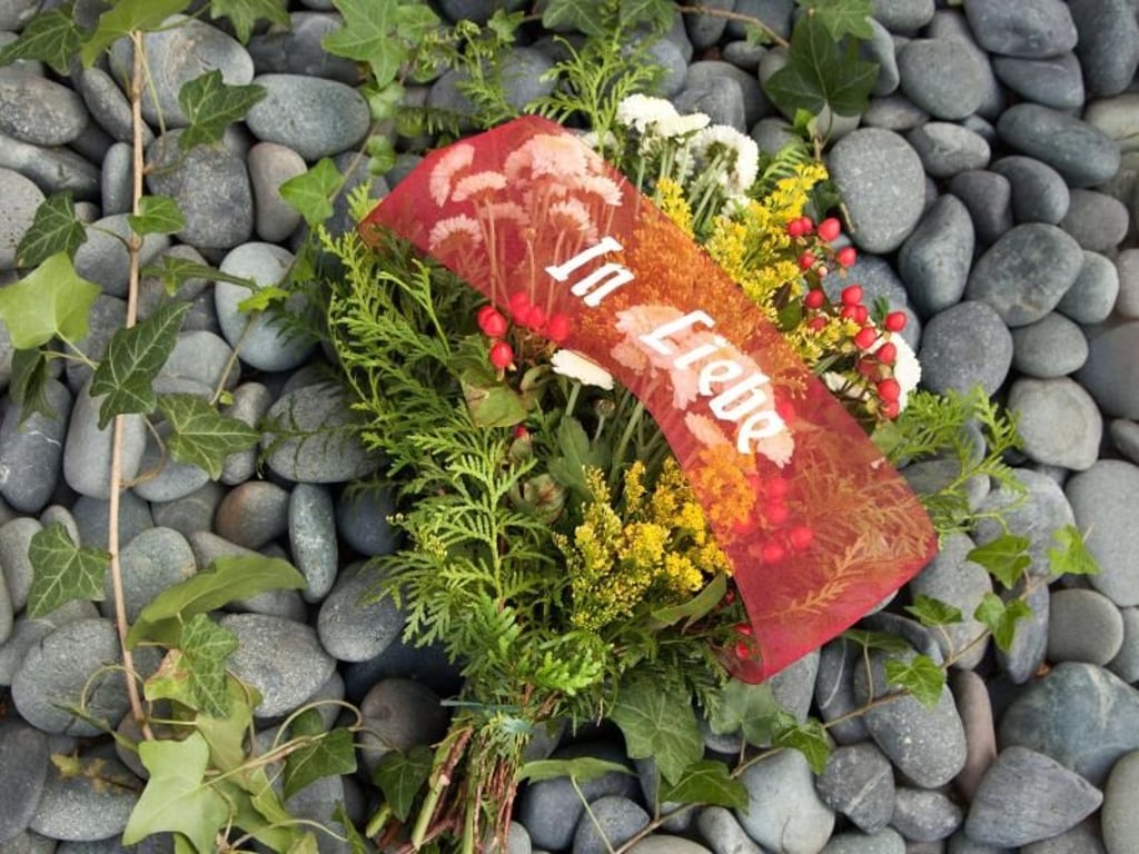 Gestecke mit Spruchbändern und frischen Farben - der Trend geht zu individuell gestalteten Grabschmuck, der etwa die Lieblingsfarben des Verstorbenen aufgreift. Foto: Halbach Seidenbänder GmbH
