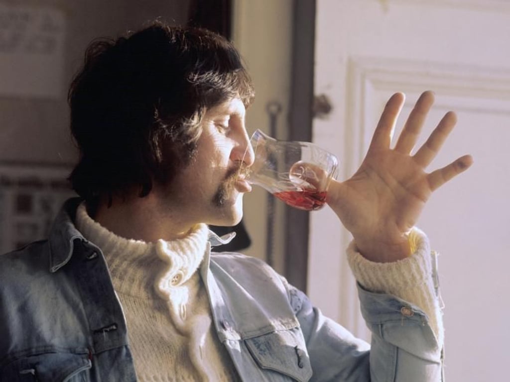 Luigi Colani mit einem von ihm gestalteten Weinglas, das statt Stiel eine Vertiefung im Boden hat. Foto: Horst Ossinger