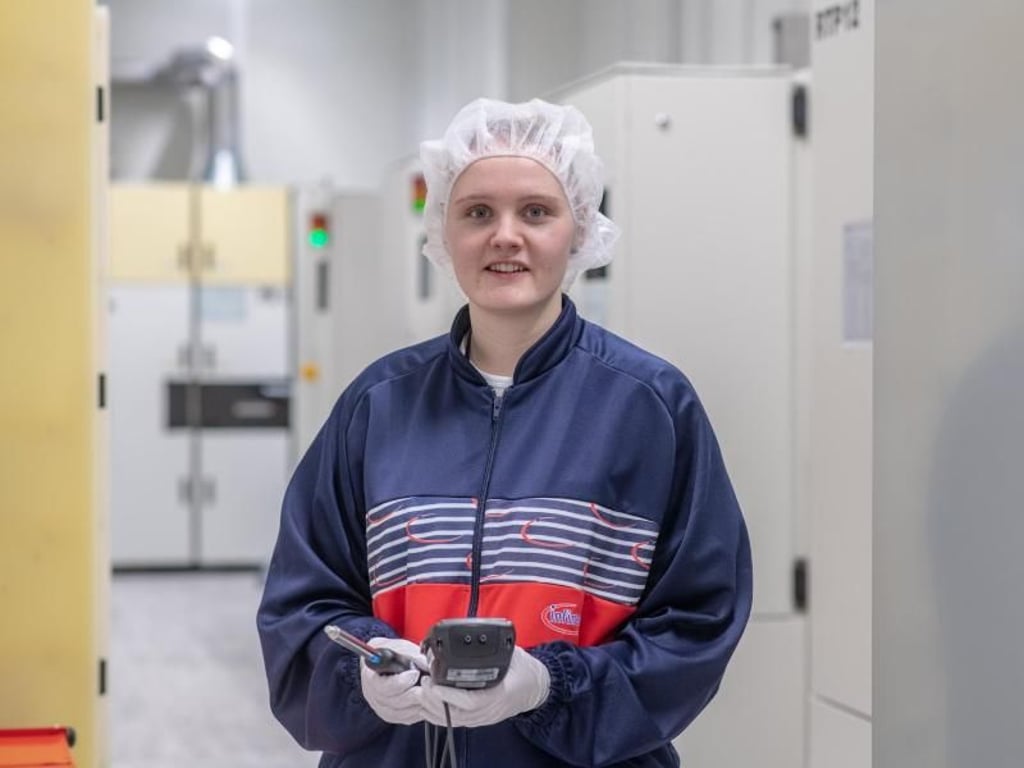 Als angehende Mikrotechnologin arbeitet Laura Zweckerl im Grau- und im Reinraum, einem möglichst staubfrei gehaltenen Raum. Hier im Grauraum misst sie mit einem besonderen Messgerät, ob eine elektrostatische Aufladung der Wafer vorliegt. Foto: Armin Weigel
