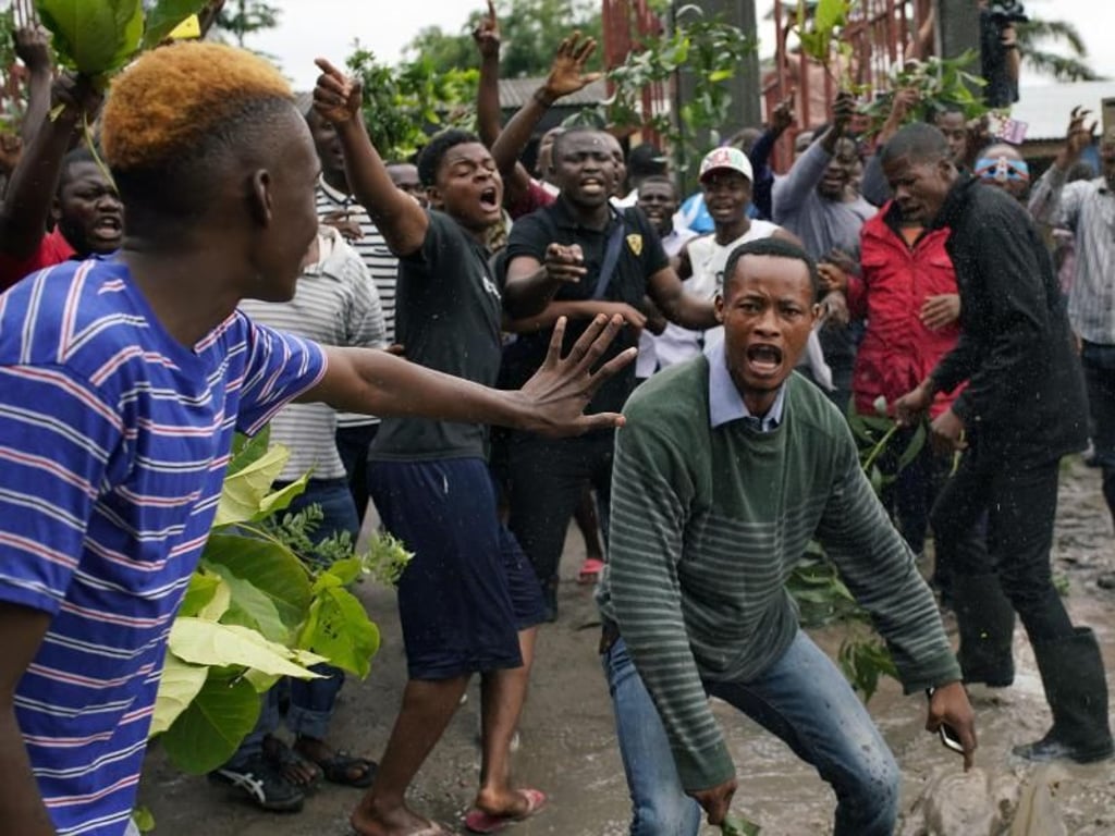 Wähler unterbrechen vor einem Wahllokal in Kinshasa eine Ansprache von Corneille Nangaa, Präsident der unabhängigen nationalen Wahlkommission (CENI), mit Zwischenrufen. Foto: Jerome Delay/AP