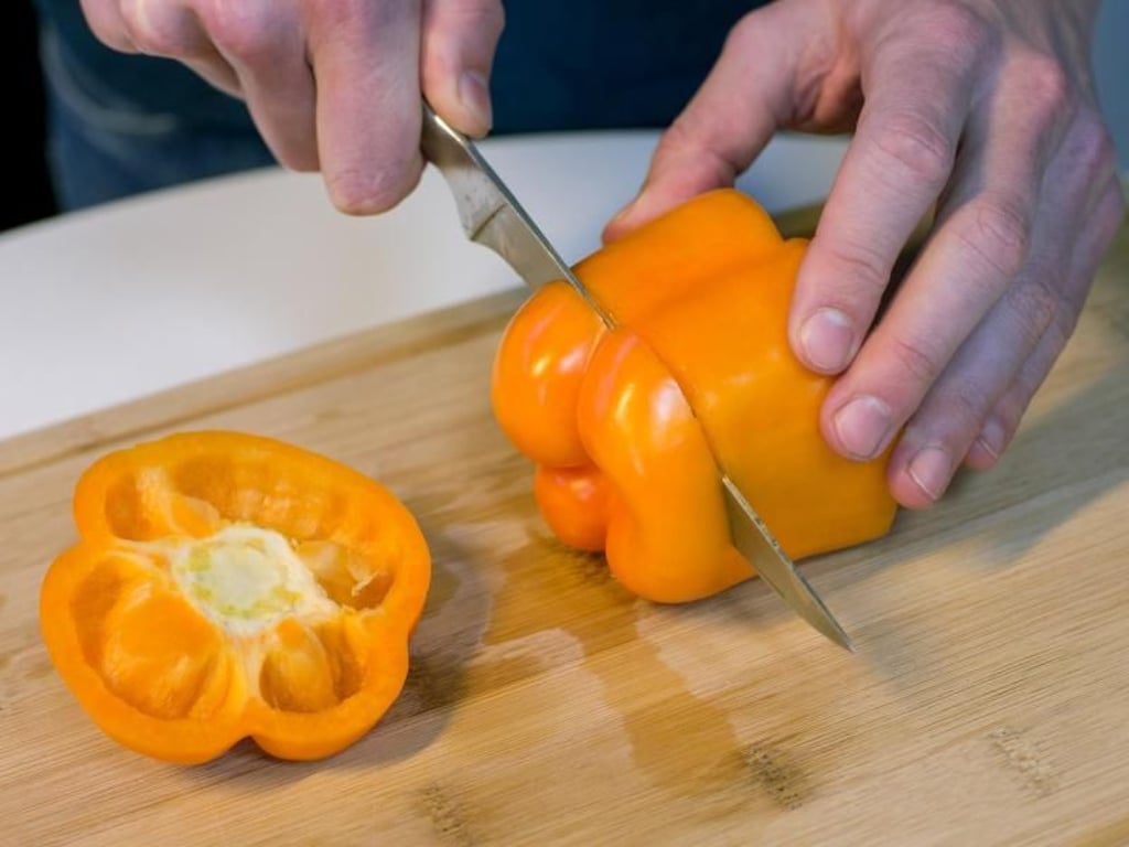 Schritt 2: Die Paprika umdrehen und das untere Ende abtrennen. Foto: Karolin Krämer