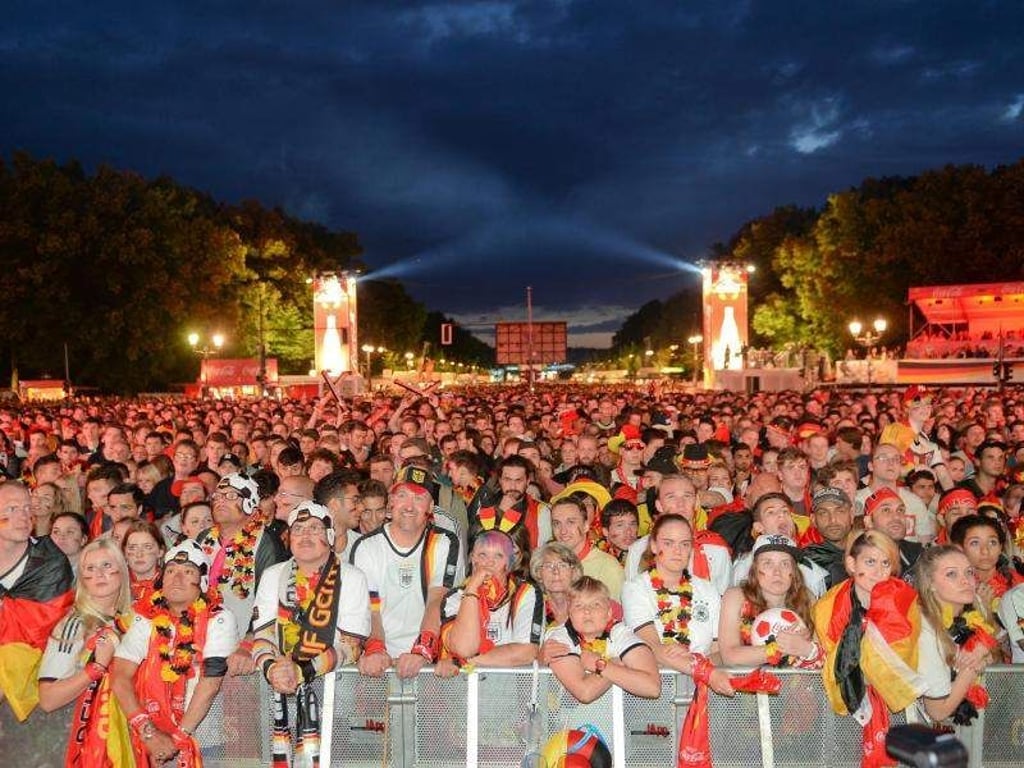 Fans verfolgen während der Europameisterschaft 2016 auf der Fanmeile vor dem Brandenburger Tor in Berlin das Viertelfinale zwischen Deutschland und Italien. Foto: Britta Pedersen