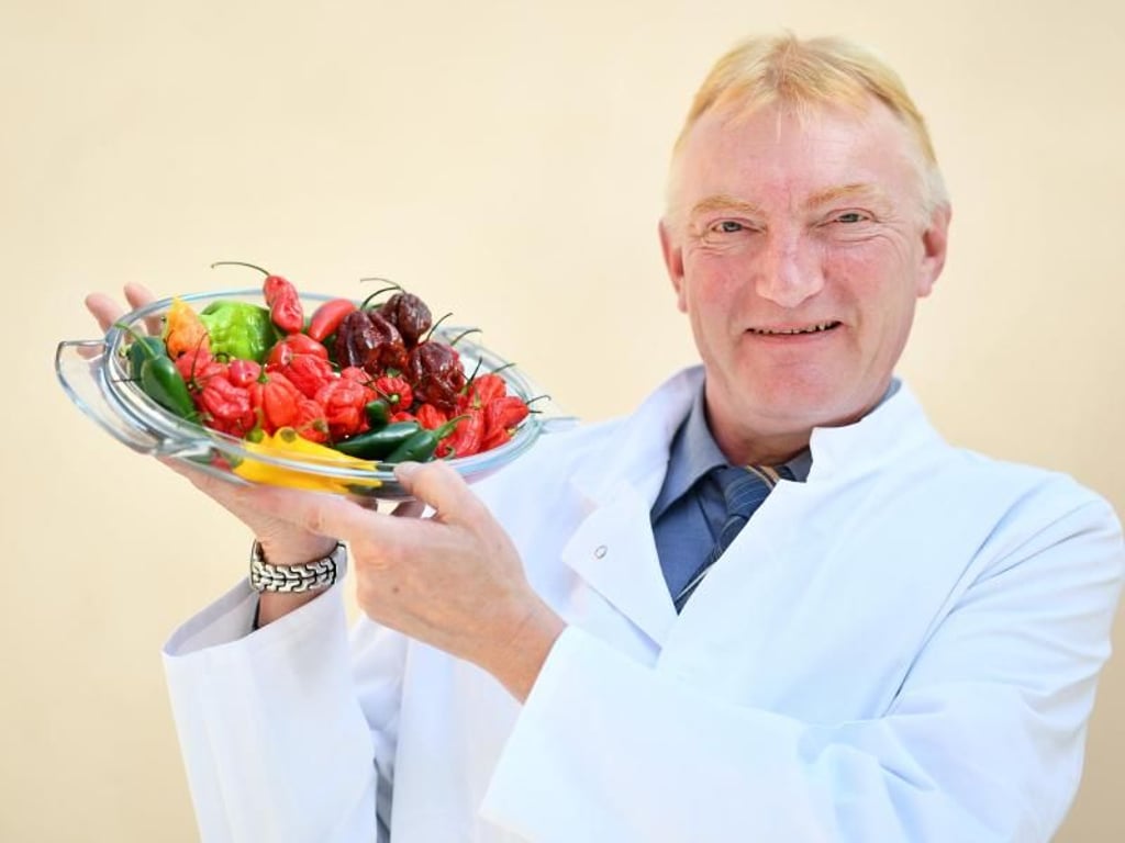 Gewürzhändler Jörg Ceglarek hält einen Teller mit verschiedenen Chilisorten in den Händen. Foto: Uwe Anspach