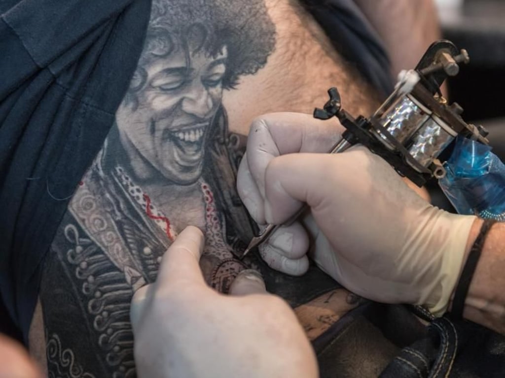 Porträts sind beliebte Motive: Tätowierer Maik Frey arbeitet hier an einem großflächigen Jimi-Hendrix-Tattoo. Foto: Daniel Maurer