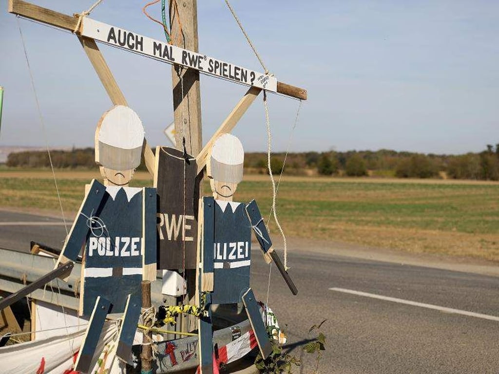 Hampelmänner von Braunkohlegegnern hängen am Hambacher Forst am Straßenrand. Foto: Oliver Berg