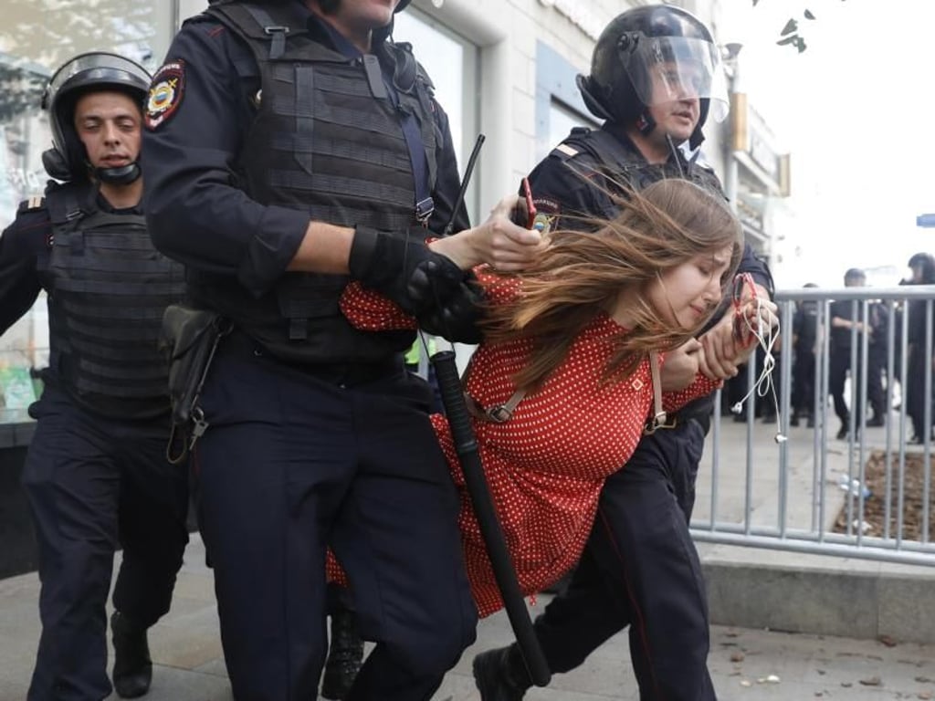Polizisten führen eine Frau in Moskau ab. Foto: Pavel Golovkin/AP