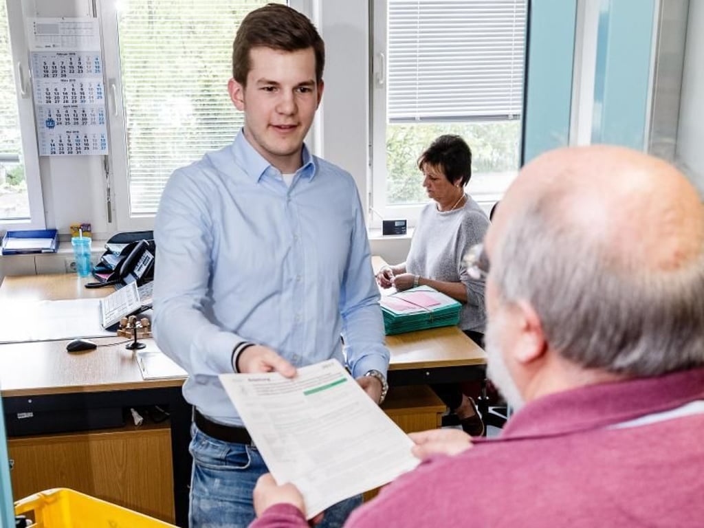 Auch das gehört zum Beruf: Azubi Christopher Ruttmann nimmt die Steuerunterlagen eines Bürgers persönlich in Empfang. Foto: Markus Scholz