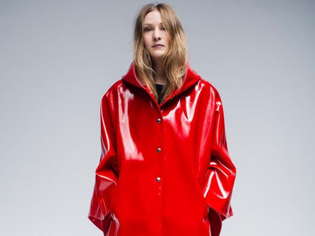 Der Schnitt ist hochmodern, das Rot ein farbenfroher Fleck an einem grauen Regentag - das Cape stammt von Stutterheim Raincoats (Cape 315 Euro). Foto: Stutterheim Raincoats/Jesper Brandt