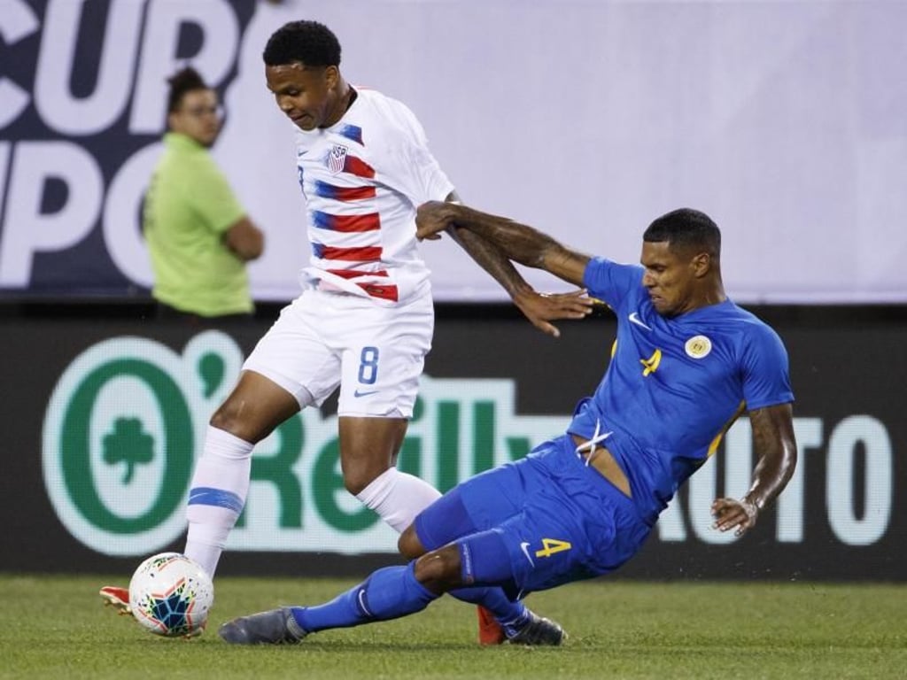 US-Spieler Weston Mckennie (l) gegen Darryl im Duell um den Ball mit Lachman von Curacao. Foto: Matt Slocum/AP