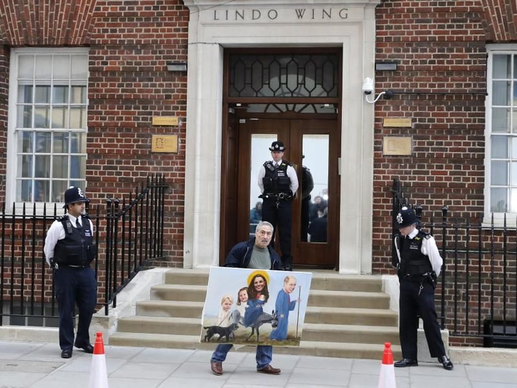 Als Kate ihr erstes Kind erwartete, tauchte der Künstler Kaya Mar bereits mit einem seltsamen Porträt der Herzogin vor dem St. Mary?s Hospital auf. Diesmal hat er William, Kate und die beiden Kinder gleich als Heilige Familie gemalt. Tja... Foto: Frank Augstein/AP
