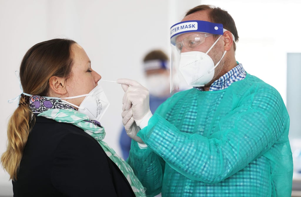 08.03.2021, Nordrhein-Westfalen, Hagen: Ein Apotheker nimmt in einem Nebenraum bei einer Frau einen Abstrich in der Nase vor. Die kostenlosen Corona-Schnelltests für alle Bürger wurden wegen vieler ungeklärter Fragen zunächst nur von wenigen Apotheken in Nordrhein-Westfalen schon am Starttag angeboten. (Zu dpa/lnw: "Kostenlose Schnelltests erst in wenigen Apotheken möglich") Foto: Oliver Berg/dpa +++ dpa-Bildfunk +++