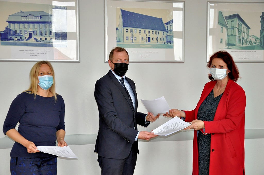 Theaterfördervereinschefin Bianca Görke (rechts) und OB Sven Wagner tauschen ihre Exemplare über den Grundstücks-Überlassungsvertrag aus. Links Vereinsvorstandsmitglied Andrea Löbel.