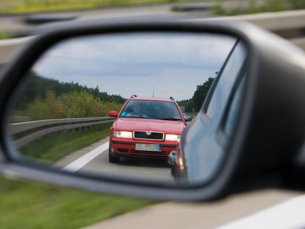Blick in den Außenspiegel eines Pkw auf einen Drängler, der mit seinem Wagen viel zu Dicht aufgefahren ist. Foto: Patrick Pleul/Archiv