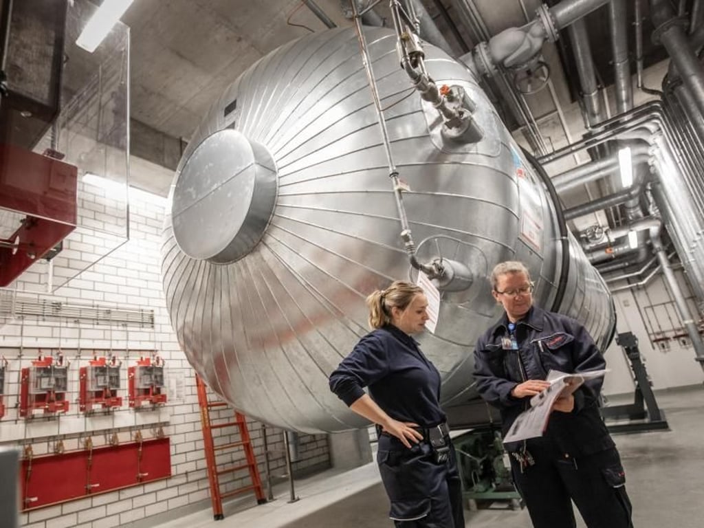 Werkfeuerwehrfrau Hannah Netzer(l) steht mit ihrer Kollegin Bettina Andres vor einem Löschtank. 40 Tonnen CO2 fassen solche Behälter. Foto: Frank Rumpenhorst