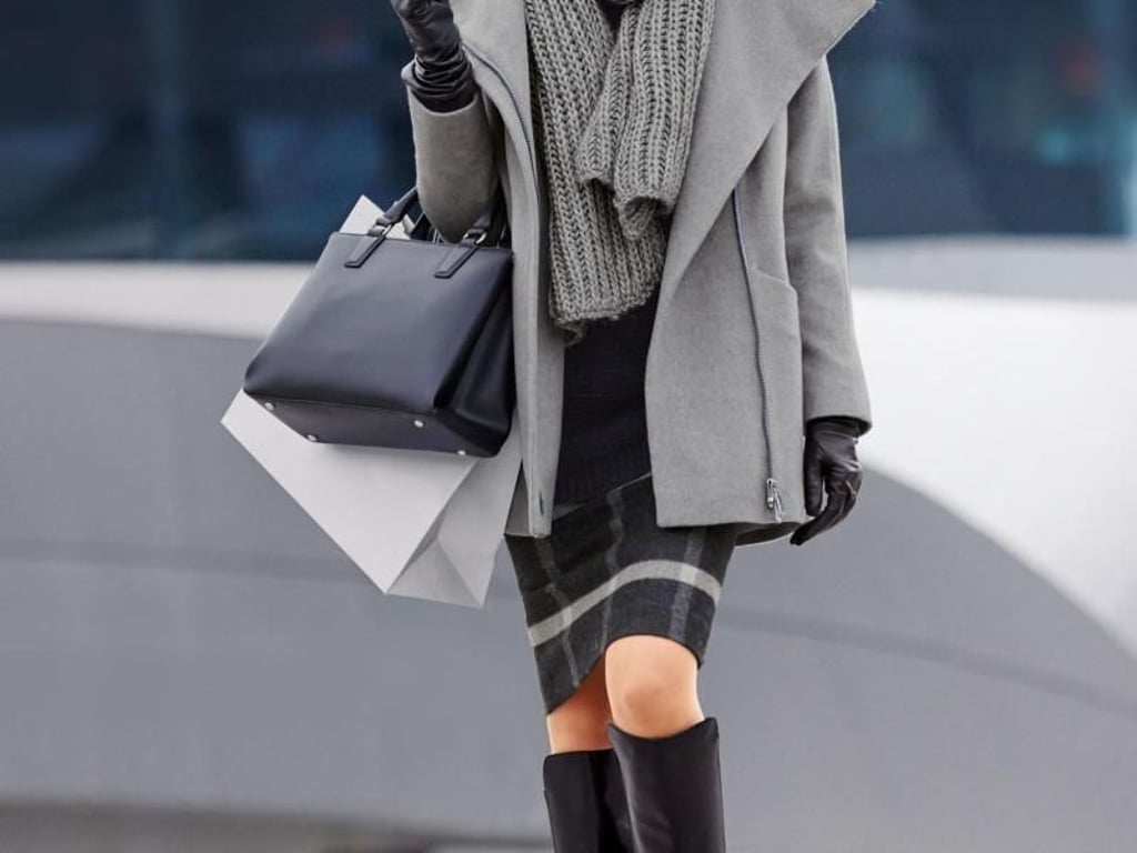 Gut kombinieren lässt sich der graue Tweed-Mantel etwa mit einem Karo-Rock, hier von Madeleine (Jacke ab 299 Euro, Karorock ab 120 Euro, Schal ca. 40 Euro, Tasche 249 Euro, Handschuhe ca. 150 Euro, Sonnenbrille ca. 100 Euro, Stiefel ca. 170 Euro). Foto: Madeleine